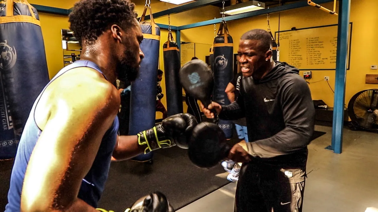 Experienced boxer and coach working focus mitts