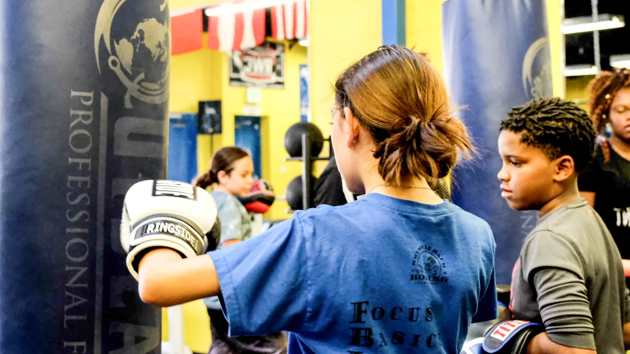 Youth class training together on heavy bags